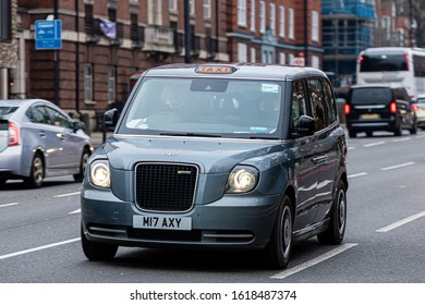 London, England, UK - December 31, 2019:   Typical black London cab in city streets. Traditionally Taxi cabs are all black in London but now produced in various colors. - image