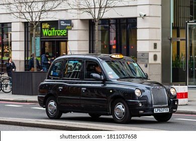 London, England, UK - December 31, 2019:   Typical black London cab in city streets. Traditionally Taxi cabs are all black in London but now produced in various colors. - image