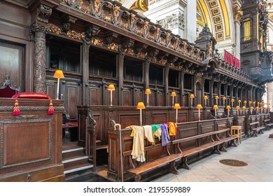 London, England, UK - July 6, 2022: St. Paul's Cathedral. Dark Wooden, Highly Decorated Church Choir VIP Benches. Orange Lights, Colorful Textiles And Golden Decorations.