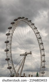 London, England, UK - July 6, 2022: From Thames River. London Eye Circle Against Dark Heavy Cloudscape.