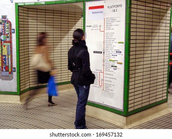 LONDON, ENGLAND, UK - MARCH 08, 2008: Passengers walking in the London Underground known as the tube, reading a map