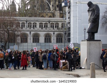 London, England, United Kingdom: 02/14/2020: Churchill Statue Overlooking Students Striking For Climate Action At Parliament Square