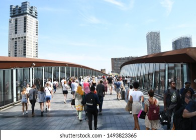 LONDON , England / United Kingdom August 2019 People cross footbridge to Westfield Stratford City shopping centre.
