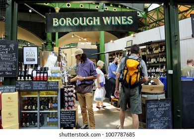 LONDON, ENGLAND-6 JULY 2013: Customers looking for wines in Borough Wines in Borough Market. It is one of the largest and oldest renowned food and drink Market in London, England, UK