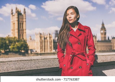 London Fashion Model In Autumn Trench Coat. Asian Woman Wearing Stylish Red Fall Jacket Visiting Westminster And Big Ben, Europe Traveler.