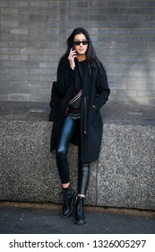 LONDON - FEBRUARY 15, 2019: Stylish Attendees Gathering Outside 180 Strand For London Fashion Week. The Girl In Black Coat And Leather Pants In Tight-fitting Talking On Phone