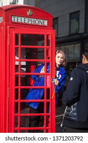 LONDON - FEBRUARY 17, 2019: A Woman Posing Against The Background Of A Red Phone Booth