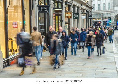 London- February, 2018: Regent Street Shoppers. Many People Motion Blurred And Carrying Shopping Bags Past Fashion Shops
