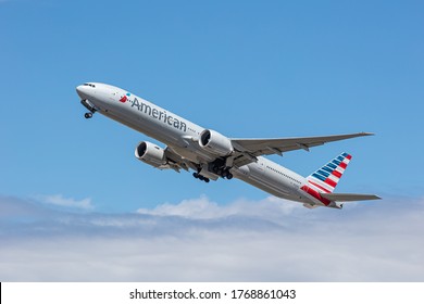 London, Heathrow Airport, June 2020 - American Airlines, Boeing 777, taking off through the clouds into a bright blue sky during the middle of the Coronavirus Pandemic. image Abdul Quraishi.