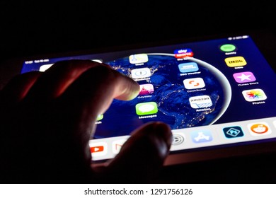 LONDON - JANUARY 15, 2019: Hand Using IPad Touch Screen Tablet Computer At Night