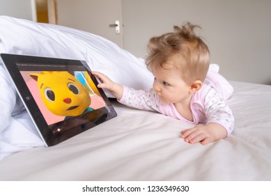 LONDON - JANUARY 31, 2015: Six month old baby watching children's cartoon on Youtube on an iPad