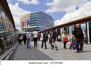 LONDON - JULY 5: People cross footbridge to Westfield Stratford City shopping centre on July 5, 2012 in London. It is the 3rd largest shopping centre in the United Kingdom.