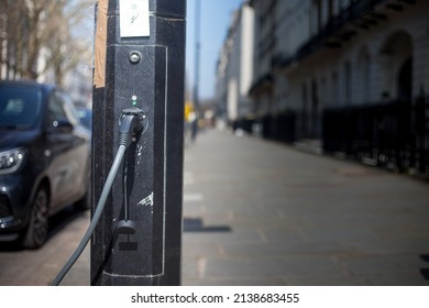 London, March, 2021, UK - A Close Up Shot Of A London Street With A Electric Car Plug Attached To A Electric Vehicle. You Can See The Street Environment In The Image Also. Nice Detail On The Plug.