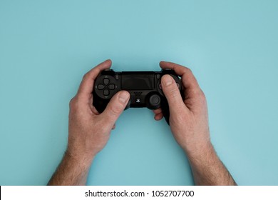 LONDON - MARCH 22, 2018: Man Playing Video Games Holding PlayStation Gaming Controller In Hands