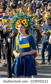 LONDON - March 26 2022: A Young Woman At The Ukraine Vigil Stands Out From The Crowd, Wearing A Traditional Vinok (flower Crown) In Blue And Yellow While Holding A Ukrainian Flag