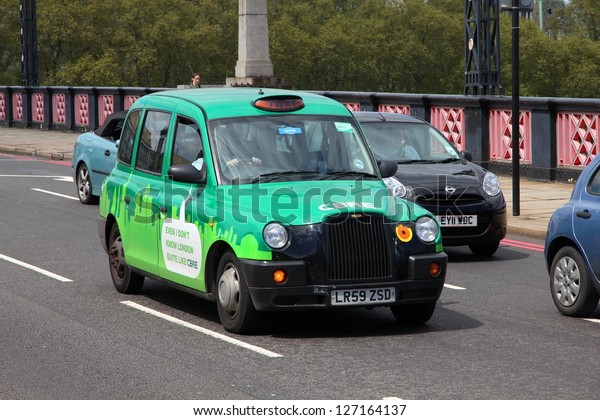 LONDON - MAY 13: Taxi cab drives on May 13, 2012\
in London, England. As of 2012, there were 24,000 licensed taxi\
cabs in London.