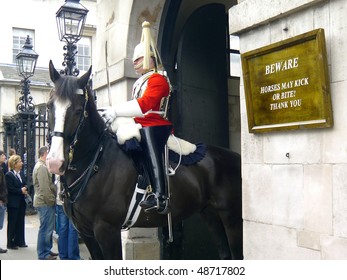 LONDON - MAY 17: A Royal horse guard before Whitehall with warning sign about kicking horses on 17th of May, 2007 in London, United KIngdom