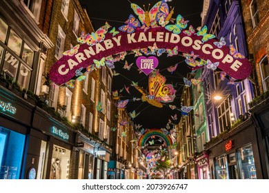 LONDON - NOVEMBER 13, 2021: Carnaby Street in London is decorated with over 600 sparkling 3D and 2D butterflies  decorated with reflective wings and bright neon patterns this Christmas. 