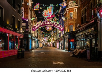 LONDON - NOVEMBER 13, 2021: Carnaby Street in London is decorated with over 600 sparkling 3D and 2D butterflies  decorated with reflective wings and bright neon patterns this Christmas. 