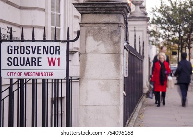 LONDON- NOVEMBER, 2017: Grosvenor Square street sign with pedestrians out of focus. A large park square in Mayfair, London. Notable for being the home to the dominant US embassy building.