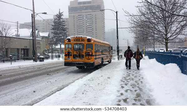 London\
Ontario, Canada - January 12, 2016: School bus on slippery road in\
the city during heavy snowfall as\
editorial