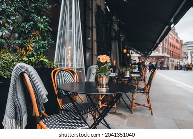 London outdoor coffee and restaurant terrace with tables, chairs and outdoor heater 
