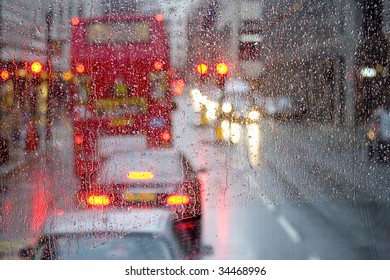 London Rain View To Red Bus Through Rain-specked Window