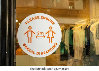 London- September, 2020: 'Please Ensure Social Distancing' Sign On Shop Window On London High Street Referring To The 2 Metre Rule To Stop The Spread Of Coronavirus