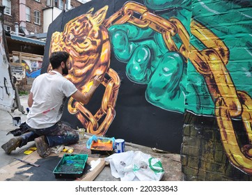 LONDON - SEPTEMBER 27. Street Artist At Work On Derelict Site Hoarding On September 27, 2014 In Hanbury Street In The East End Of London, UK.