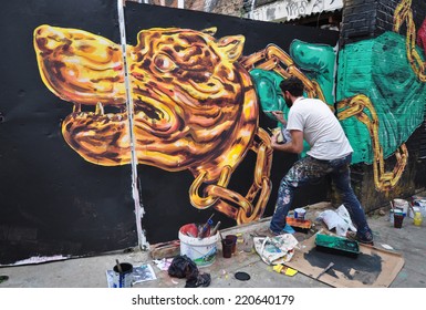 LONDON - SEPTEMBER 27. Street Artist At Work On Derelict Site Hoarding On September 27, 2014 In Hanbury Street In The East End Of London, UK.