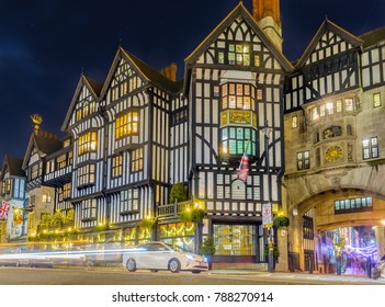 London Shopping Mall At Night During Christmas Holidays With A Car Making Light Trail Along The Street