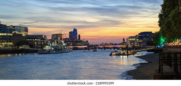 London Skyline Illuminated At Night - Looking Up The River Thames Towards Blacfriars Bridge With A Nice Orange Sunset Sky.