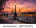 The London southbank riverside of the Thames with view to the Big Ben clocktower and Westminster Palace during a colorful sunset, United Kingdom