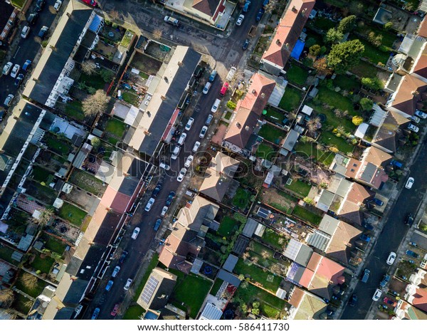 London suburbs, aerial view. Aerial drone photo\
looking down vertically onto the rooftops of a typical North London\
suburban district.