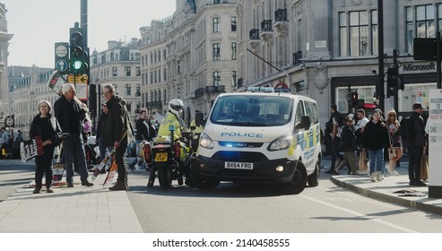 London, UK - 03 19 2022: A Met Police Van With Blue Siren Lights Flashing And A Motorbike Blocking Regent And Oxford Street, For The Yearly ‘March Against Racism’, Held Around ‘UN Anti Racism Day’.