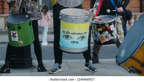 London, UK - 03 19 2022: Climate protest percussionists playing drums, ‘We Are Watching You. COP26’, at Portland Place, for the yearly ‘March Against Racism’, held around ‘UN Anti Racism Day’.