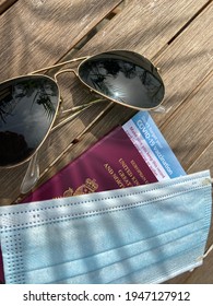 London, UK - 03.31.2021: Covid 19 Vaccine Passport Concept  For Restrictions On Travel With Sunglasses, UK Passport And Covid Mask And Vaccine ID Card 