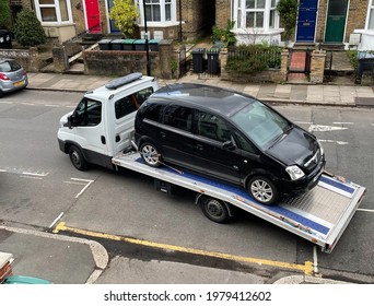 London. UK- 05.19.2021. A Vehicle Recovery Truck Carrying Away A Broken Down Car.