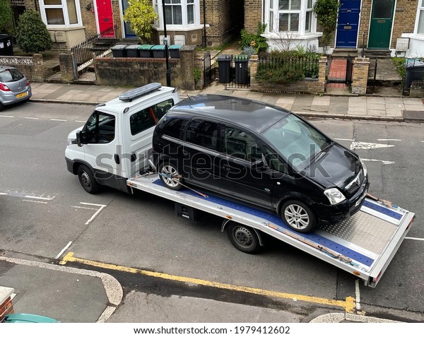 London. UK- 05.19.2021. A vehicle recovery\
truck carrying away a broken down\
car.