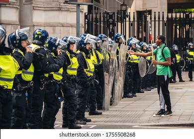 London / UK - 06/13/2020: Black Lives Matter Protest During Lockdown Coronavirus Pandemic. Young Man With BLM Banner Provoking Police Officers