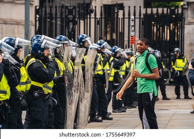 London / UK - 06/13/2020: Black Lives Matter Protest During Lockdown Coronavirus Pandemic. Young Man With BLM Banner Provoking Police Officers