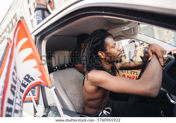 London\
/ UK - 06/20/2020: Van driver behind the wheel in front of the \
Huge crowd of Black Lives Matters protesters heading to Parliament\
Square, Westminster, chanting and holding\
banners