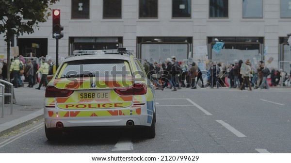 London, UK - 11 06 2021: A police car\
patrolling on a side road whilst climate activists march between\
Bank of England and Trafalgar Square for COP26 ‘Global Day of\
Action for Climate\
Justice’.