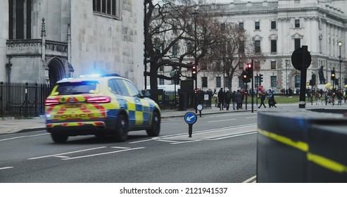 London, UK - 12 13 2021: A Police Car With Blue Siren Lights Driving On St Margaret Street Onto Parliament Square In Westminster, During Surge Of Covid Variant Omicron.