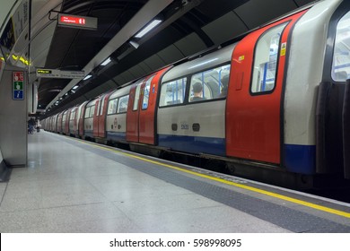 London, UK. 12th March 2017. A London Underground Tube Train At London Bridge Station On The Northern Line.  A Few Passengers Are Waiting For The Next Train In The Distance.