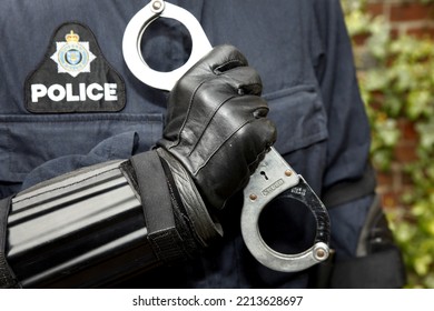 London, UK, 13th October 2022, British Police Officer Holding A Pair Of Handcuffs.

