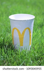 London, UK - 17 May 2018: McDonald's Drinks Cup On Vibrant Green Grass In Summer Time