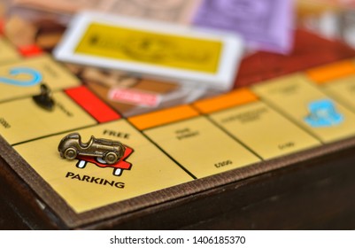 London, UK, 2020. Metal Car Game Piece With Cards In The Background Placed On Free Parking Sign On Monopoly Board Game Playing At Home In Quarantine During Lockdown 