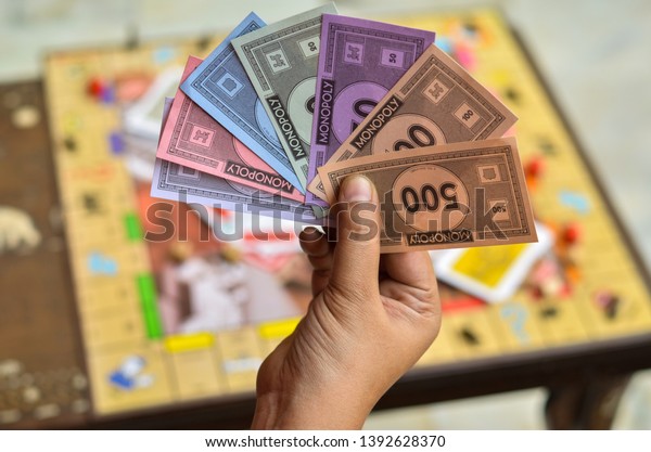 London,
UK, 2020. Player holding and neatly arranging fake money / currency
notes in his hand with the monopoly board game in the background.
Playing at home in quarantine during lockdown
