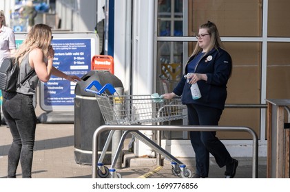 LONDON, UK - 2020: Tesco Staff Cleaning Supermarket Trolleys During Coronavirus Outbreak In London UK